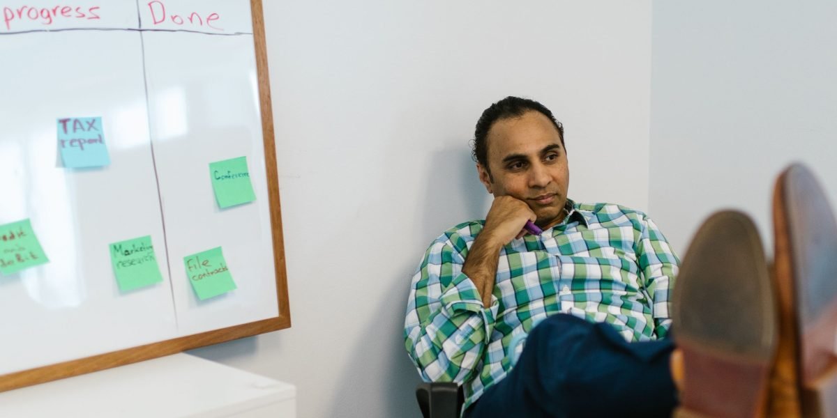 A person deep in thought, reviewing complex plans, symbolizing the challenges of global broadcast strategy.