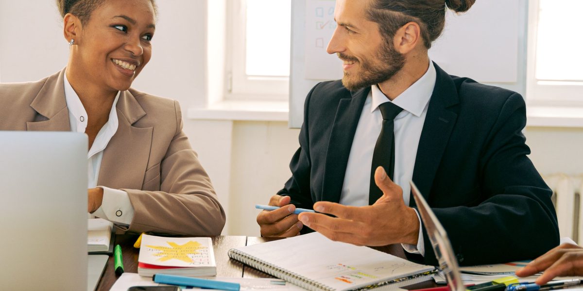 Business professionals engaged in a discussion, likely making decisions about project workflows or production models.