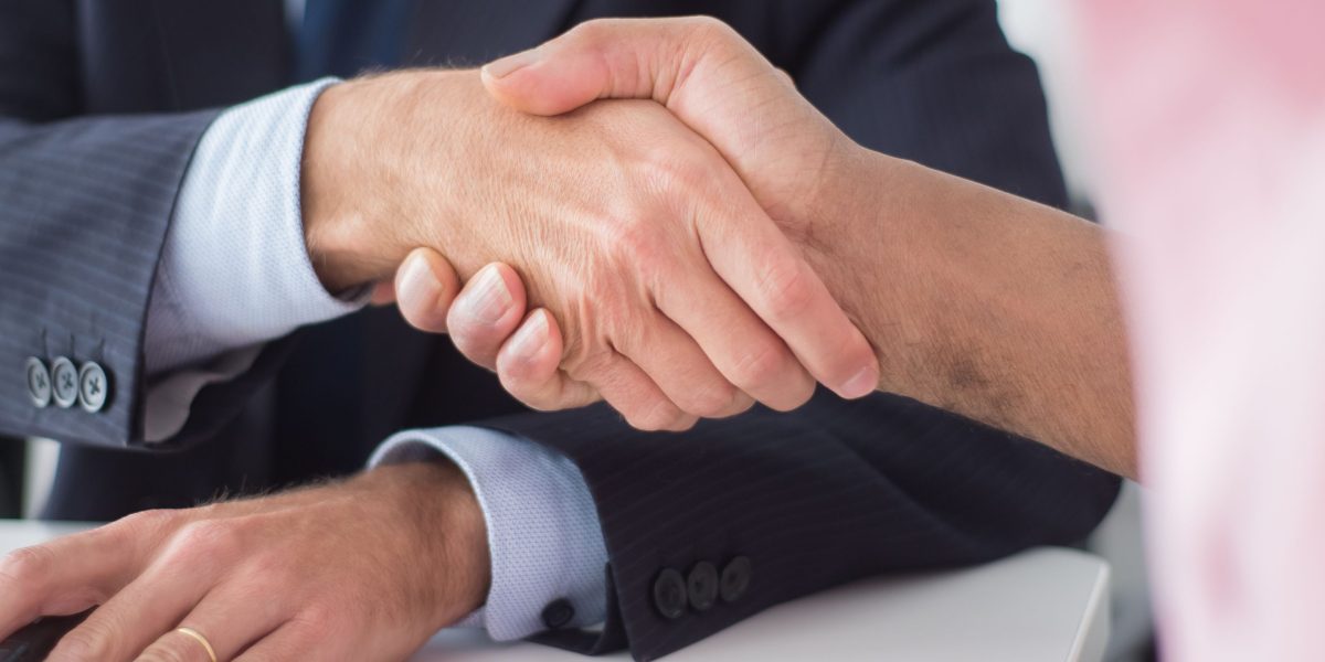 Two business partners shaking hands, symbolizing a successful agreement and strong collaboration.