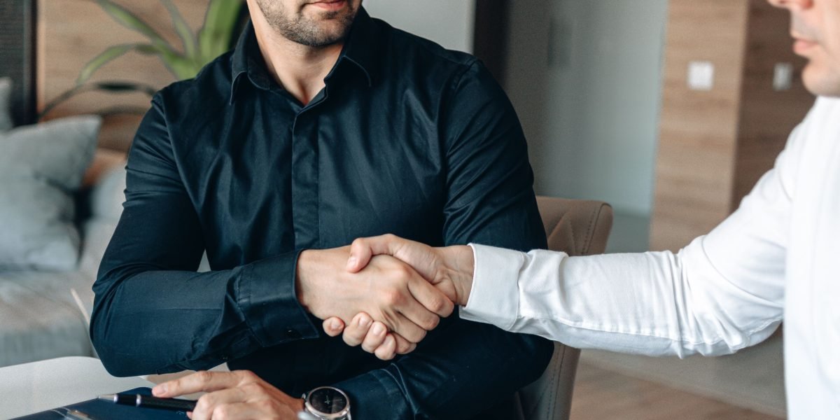 Business professionals concluding a deal with a handshake, symbolizing media rights management and commercial agreements.