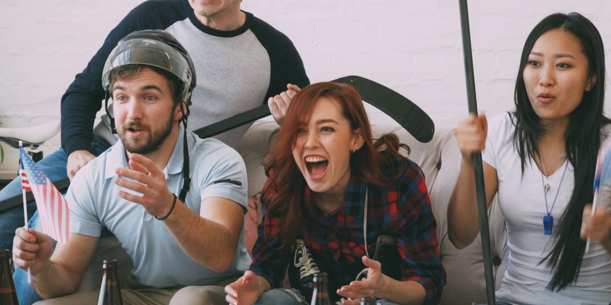 Friends enjoying a live sports broadcast, actively engaging across multiple devices.